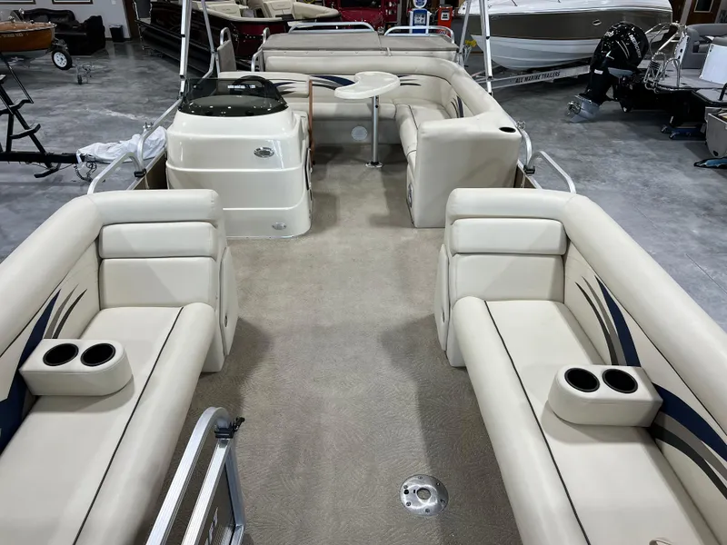 Slide: The Image of 2013 PlayCraft 2400 Clipper pontoon boat interior with beige seating and cup holders. - 7