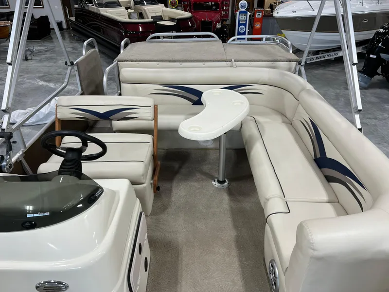 Slide: The Image of 2013 PlayCraft 2400 Clipper pontoon boat interior with white seating and steering console. - 8