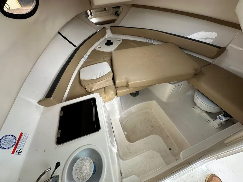 Slide: The Image of 2012 Striper 2601 Walkaround cabin interior with beige seating and compact amenities. - 11