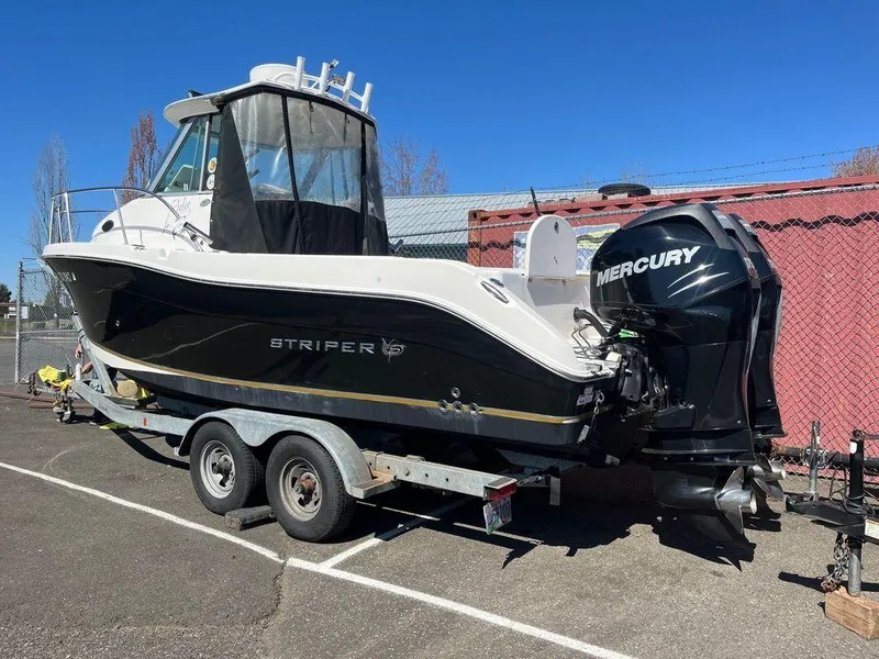 Slide: The Image of 2012 Striper 2601 Walkaround boat on trailer with Mercury outboard motor. - 2
