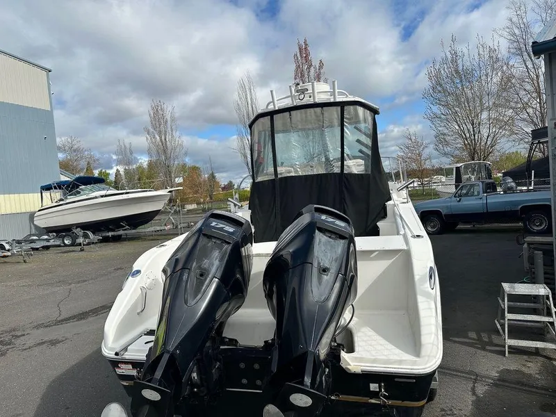 Slide: The Image of 2012 Striper 2601 Walkaround boat with dual outboard motors in a marina setting. - 3