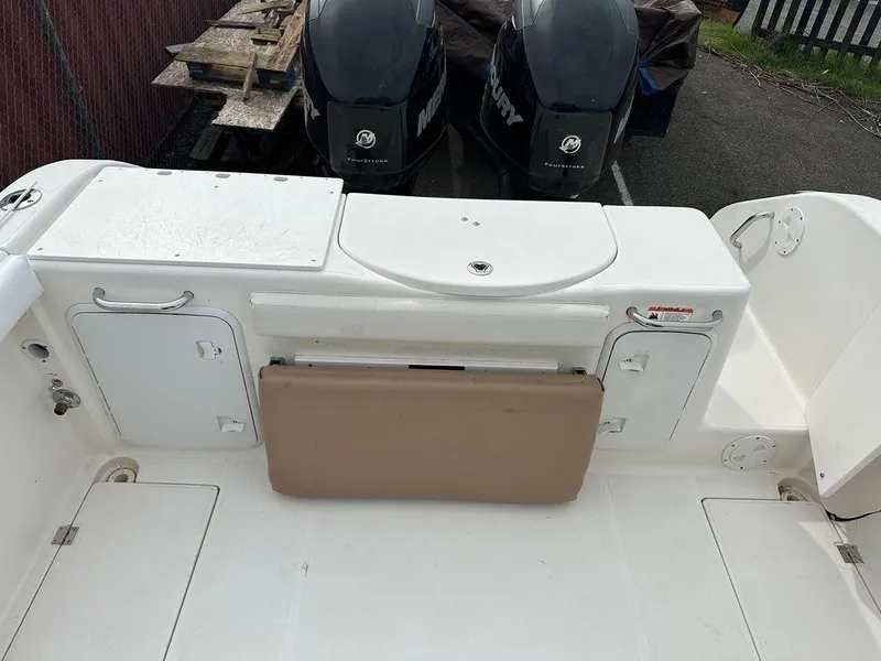 Slide: The Image of 2012 Striper 2601 Walkaround boat deck with storage compartments and dual Mercury engines. - 8