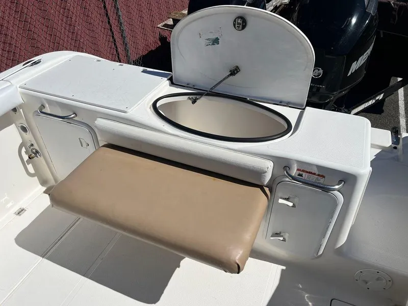 Slide: The Image of 2012 Striper 2601 Walkaround boat interior with storage compartments and cushioned seat. - 9