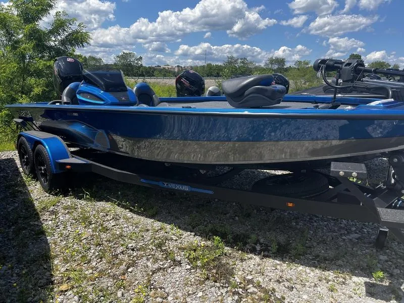 Slide: The Image of 2024 Vexus AVX 1980 boat in blue, parked on gravel under a sunny sky. - 0