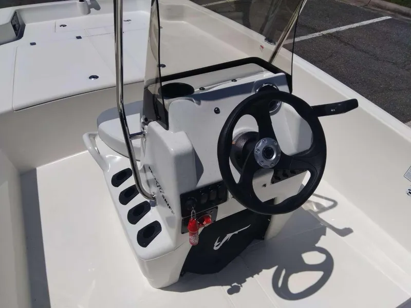 Slide: The Image of 2024 Mako Pro Skiff 17 CC center console with steering wheel and controls. - 12