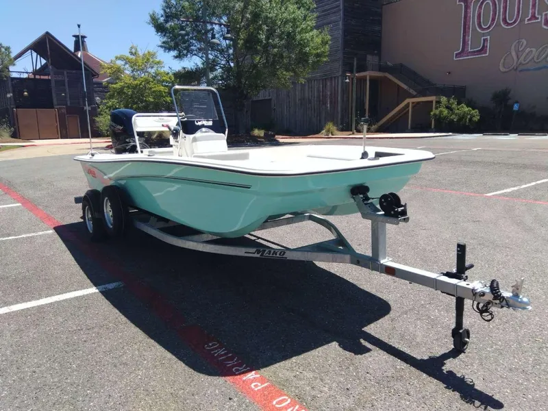 Slide: The Image of 2024 Mako Pro Skiff 17 CC boat on a trailer in a parking lot. - 6