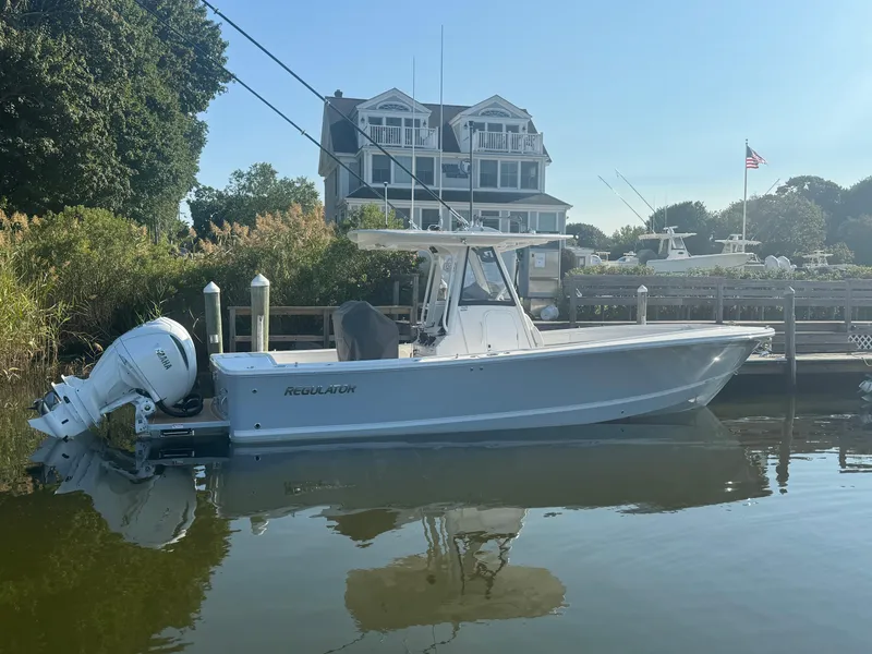Slide: The Image of 2025 Regulator 28 boat docked by a waterfront house. - 1