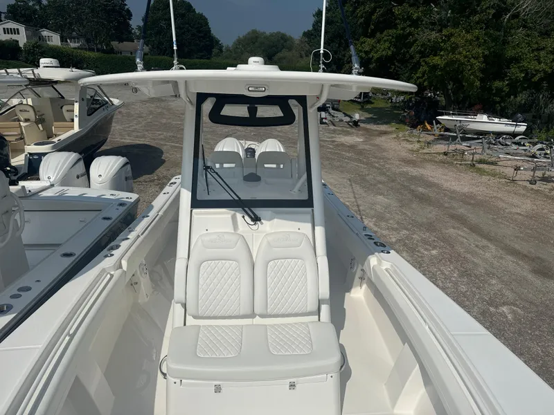 Slide: The Image of 2025 Regulator 28 boat with white seating and console, docked outdoors. - 10