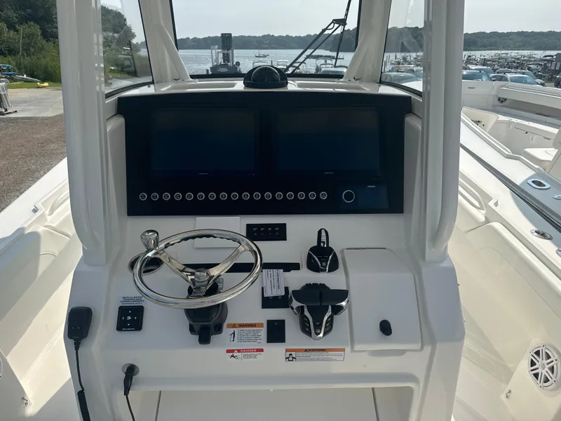 Slide: The Image of 2025 Regulator 28 boat dashboard with dual screens and steering wheel. - 11