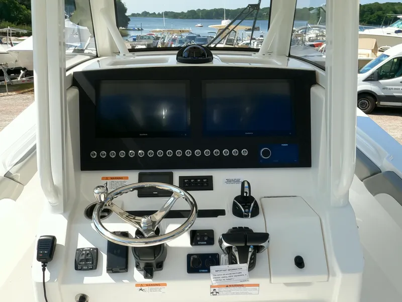 Slide: The Image of Control console of a 2025 Regulator 28 boat with dual screens and steering wheel. - 12
