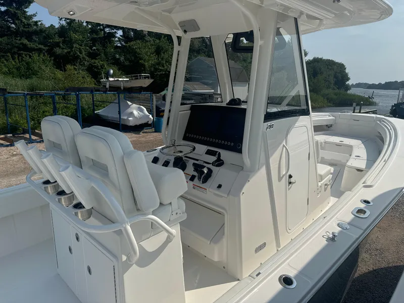 Slide: The Image of 2025 Regulator 28 boat with modern console and seating, docked near a scenic waterfront. - 9