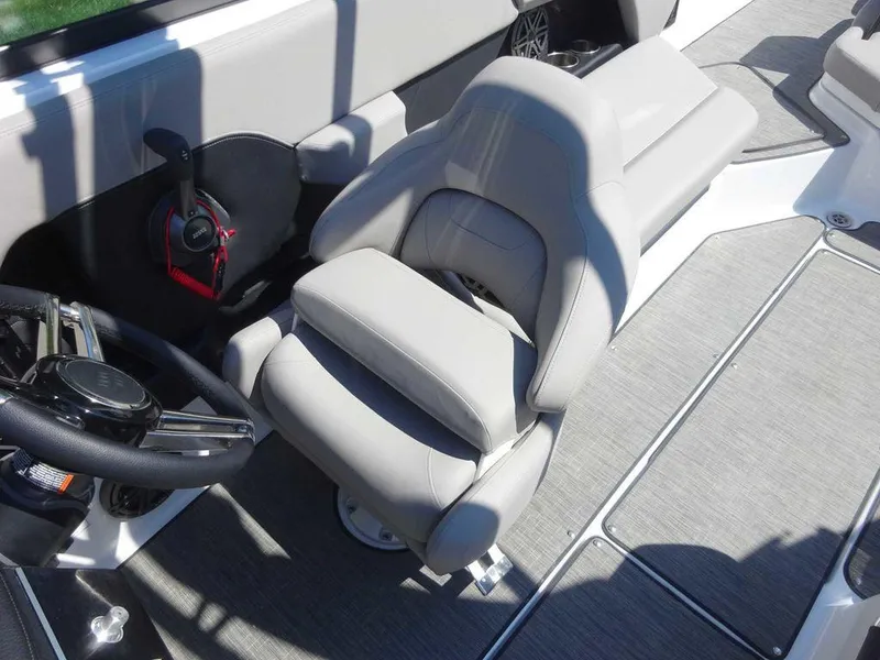 Slide: The Image of 2024 Four Winns H6 boat interior with gray captain's chair and steering wheel. - 3
