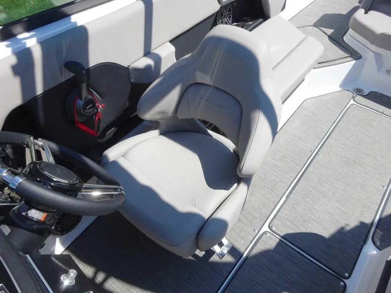 Slide: The Image of 2024 Four Winns H6 boat interior with gray seating and steering wheel. - 5