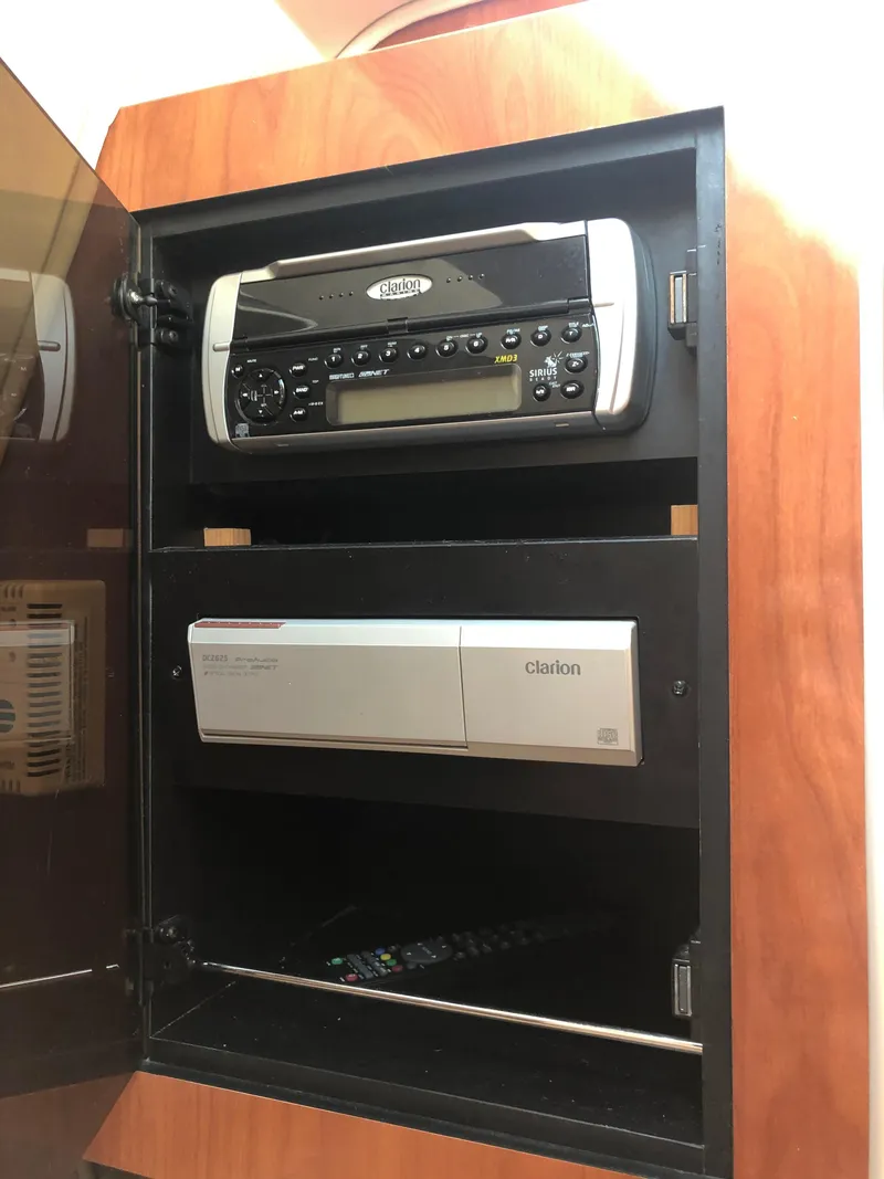 Slide: The Image of 2005 Doral Monticello audio system with stereo and Clarion components in wooden cabinet. - 10