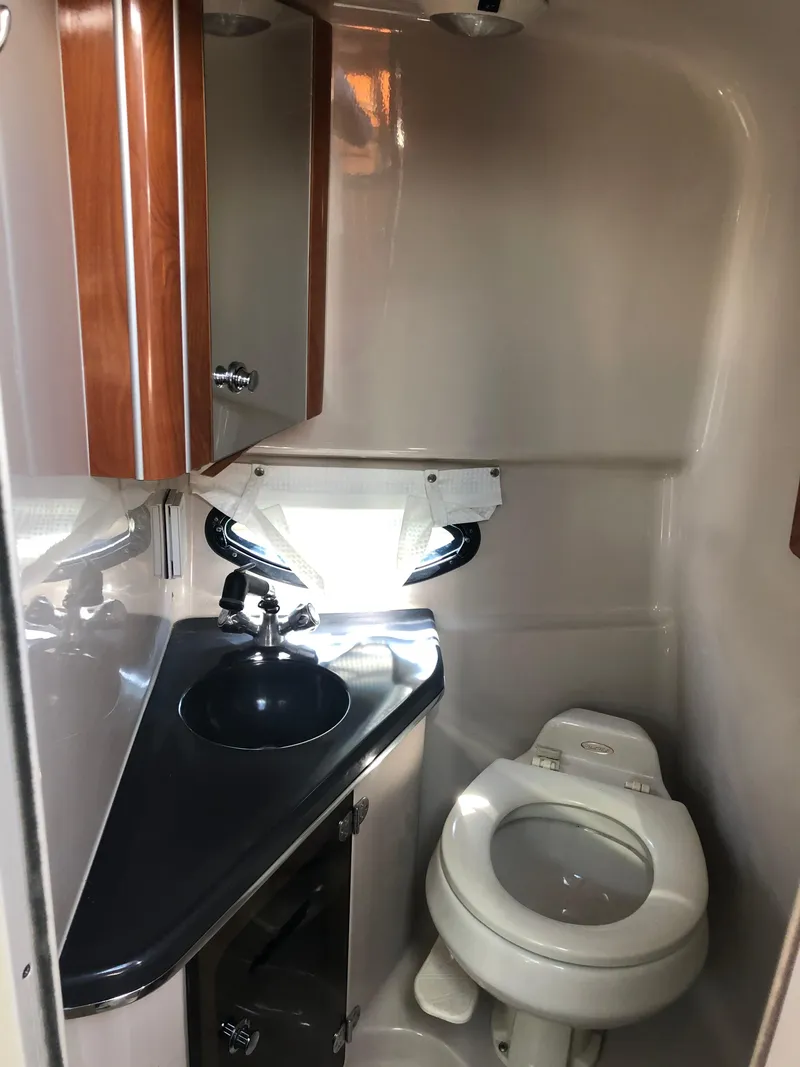 Slide: The Image of 2005 Doral Monticello boat bathroom with sink, toilet, and wooden cabinetry. - 18