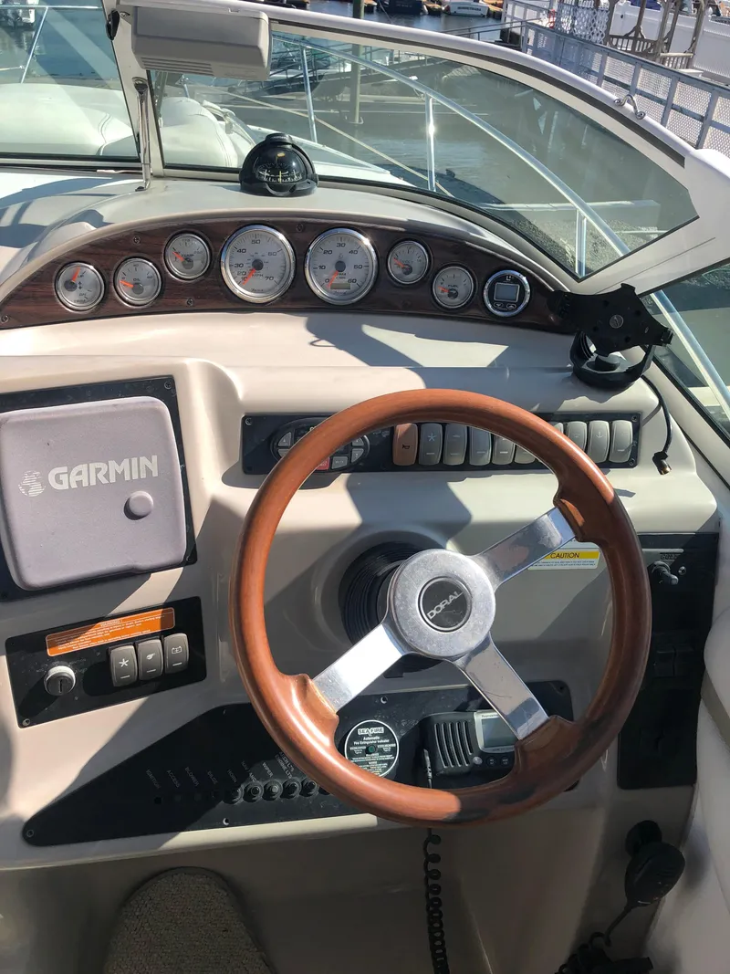 Slide: The Image of 2005 Doral Monticello boat dashboard with Garmin navigation and wooden steering wheel. - 22