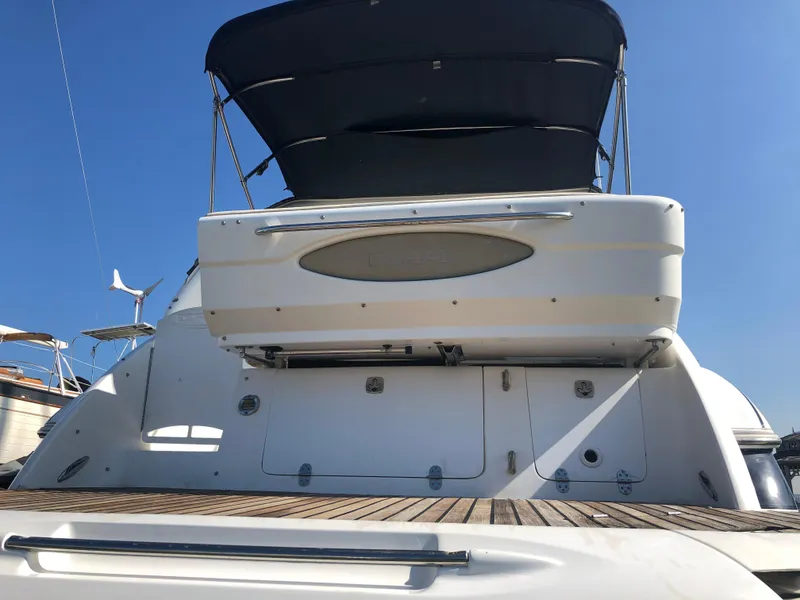 Slide: The Image of 2005 Doral Monticello yacht with a sleek design and spacious deck, under clear blue sky. - 6