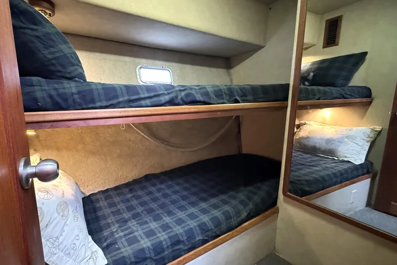 Slide: The Image of 1988 Chris-Craft 392 Commander cabin with cozy bunk beds and nautical decor. - 13