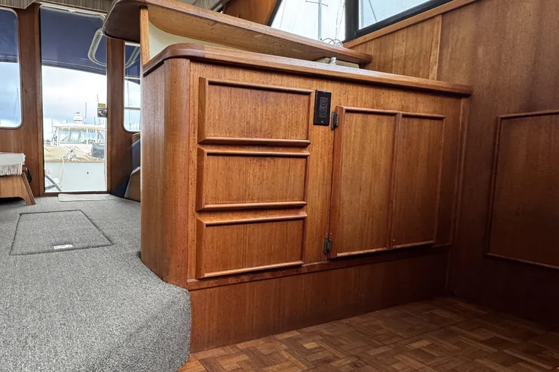 Slide: The Image of 1988 Chris-Craft 392 Commander interior with wooden cabinetry and carpeted flooring. - 15