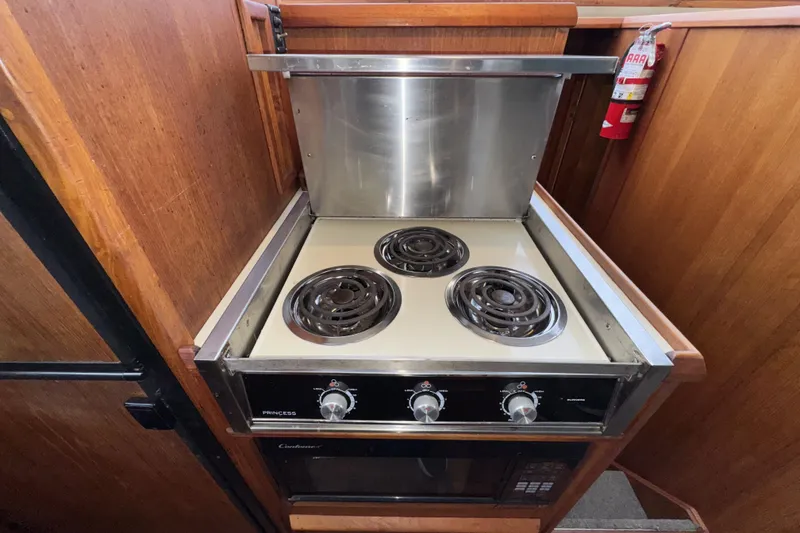 Slide: The Image of 1988 Chris-Craft 392 Commander kitchen with electric stove and wooden cabinetry. - 17