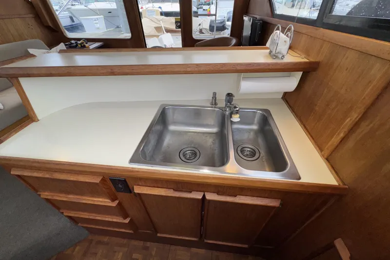 Slide: The Image of 1988 Chris-Craft 392 Commander kitchen with dual sinks and wooden cabinetry. - 18