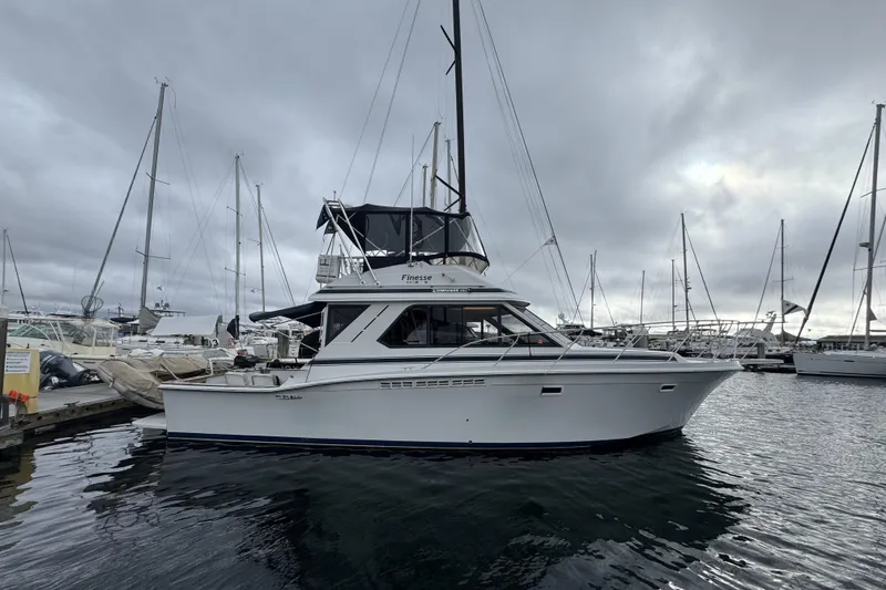 Slide: The Image of 1988 Chris-Craft 392 Commander yacht docked in a marina under cloudy skies. - 30