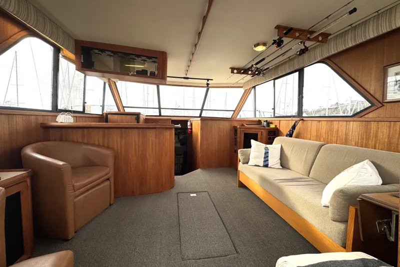 Slide: The Image of 1988 Chris-Craft 392 Commander interior with wood paneling, sofa, and armchair. - 4