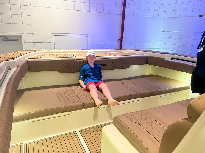 Slide: The Image of Child sitting on a 2025 BlueCat 30 boat's cushioned seating area. - 4