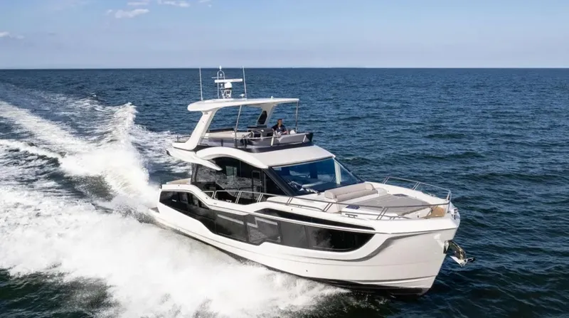 The Image of 2025 Galeon 560 Fly yacht cruising on open sea under clear blue sky. - 0