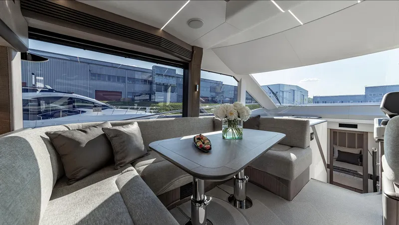 Slide: The Image of Luxurious interior of the 2024 Galeon 560 Fly yacht with modern seating and dining area. - 15
