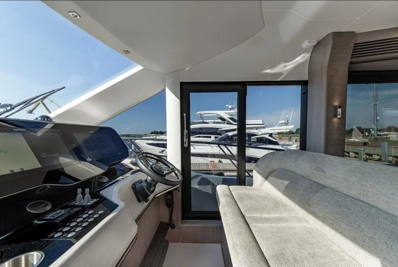 Slide: The Image of Interior of 2024 Galeon 560 Fly yacht with modern helm and seating area. - 16