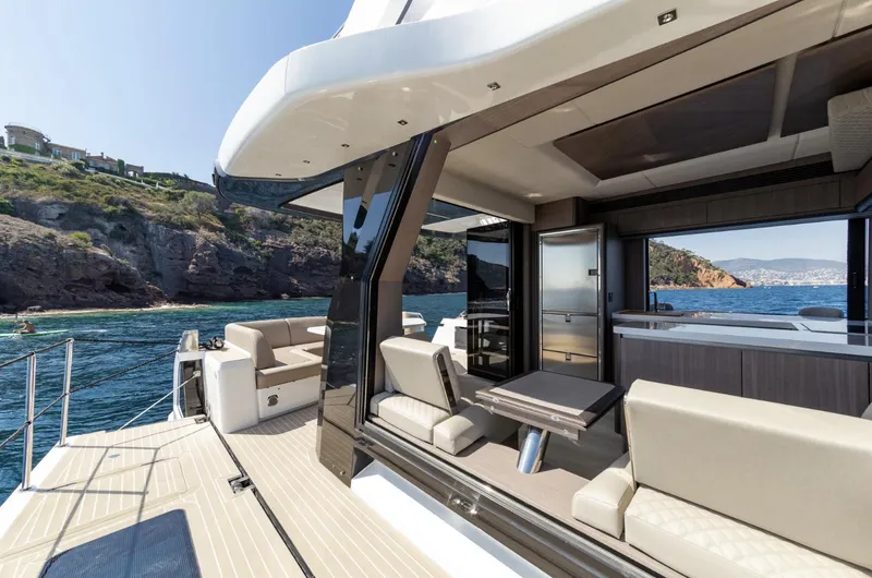 Slide: The Image of 2024 Galeon 560 Fly yacht, luxurious deck and seating area with scenic ocean view. - 5