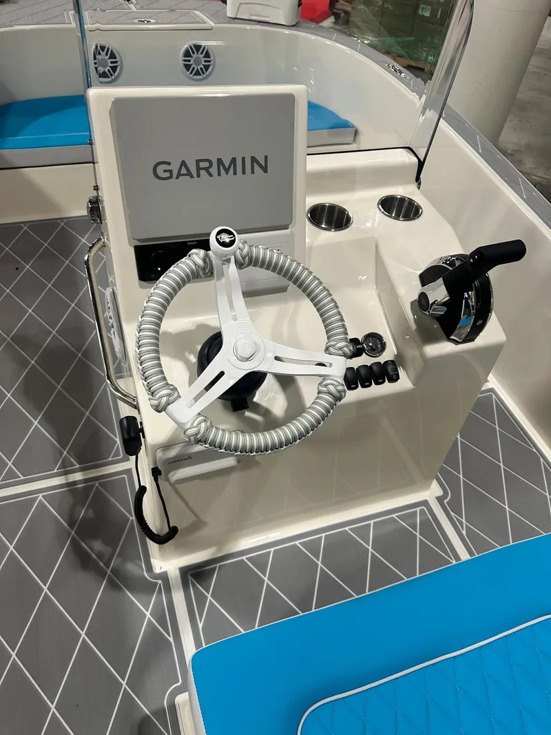 Slide: The Image of 2024 BlueCat 17 boat helm with Garmin navigation system and blue seating. - 5