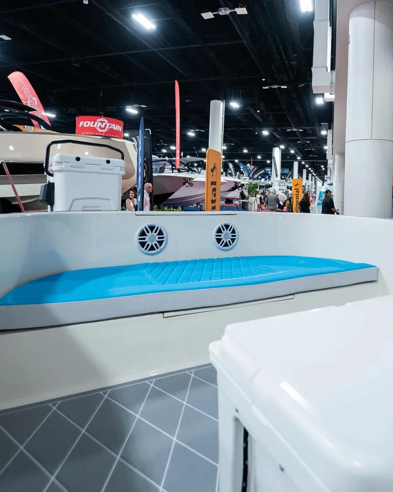 Slide: The Image of 2024 BlueCat 17 boat interior with blue seating at a boat show. - 9