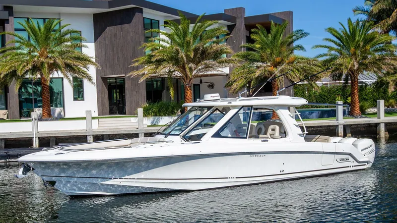 Slide: The Image of 2019 Boston Whaler 380 Realm boat docked near modern waterfront home. - 0