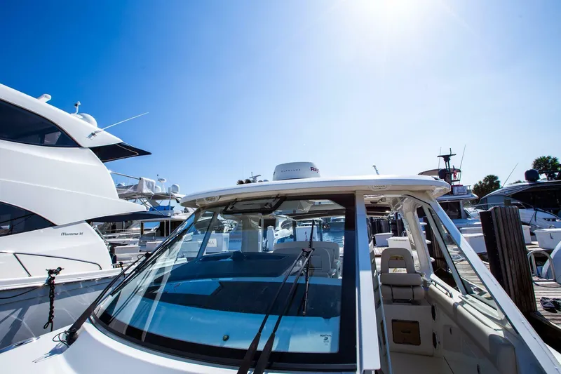 Slide: The Image of 2019 Boston Whaler 380 Realm boat docked under clear blue sky. - 8