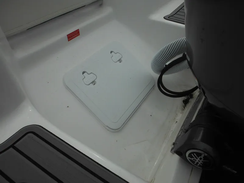 Slide: The Image of 2024 Tidewater 210 LXF boat deck with storage hatch and engine components. - 15