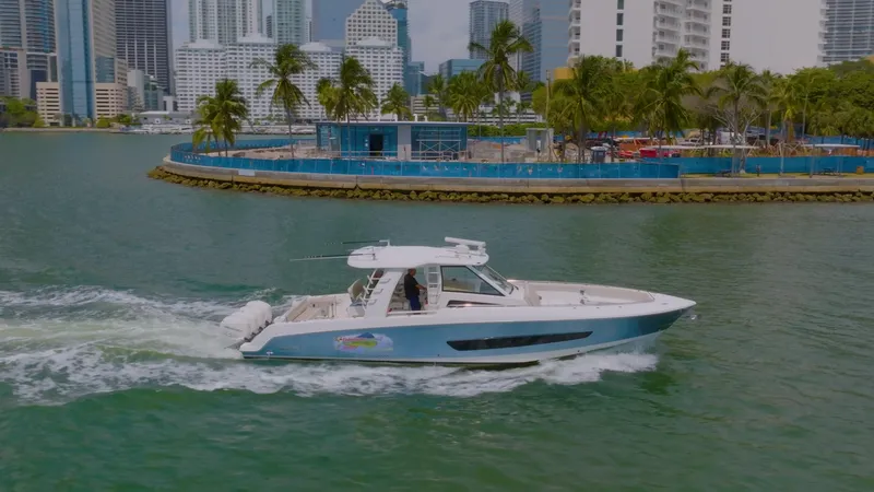 Slide: The Image of 2016 Boston Whaler 420 Outrage cruising near a city waterfront with palm trees. - 0