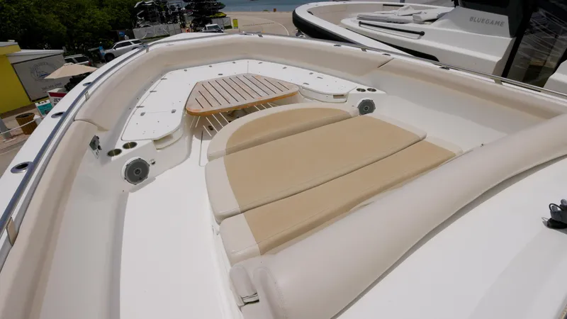Slide: The Image of 2016 Boston Whaler 420 Outrage boat with cushioned seating and wooden table. - 18