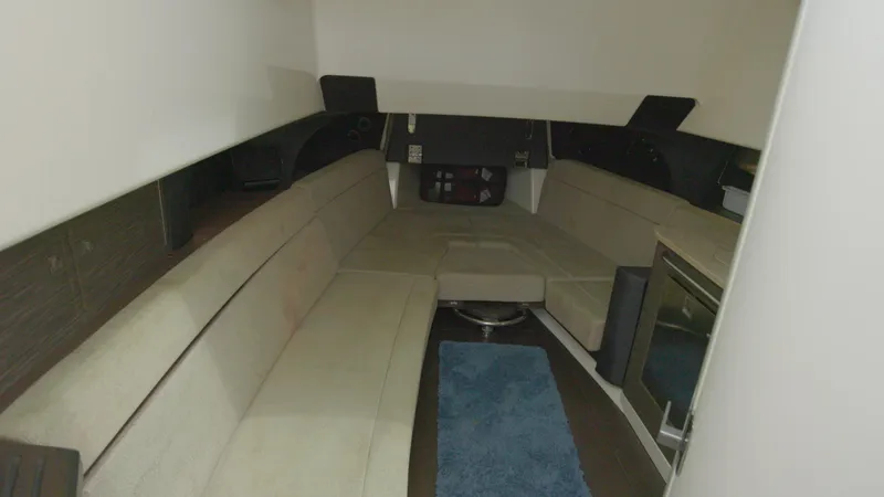 Slide: The Image of Interior cabin of a 2016 Boston Whaler 420 Outrage with beige seating and blue rug. - 21