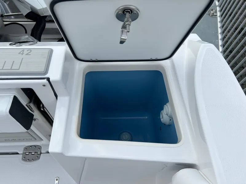 Slide: The Image of 2024 Blackfin 252 CC boat storage compartment with open lid. - 18
