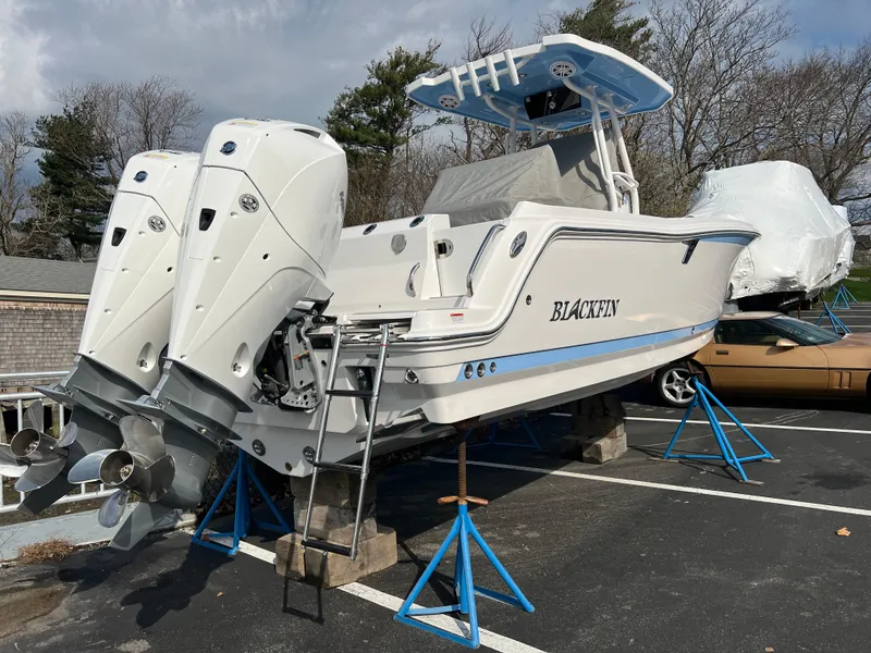 Slide: The Image of 2024 Blackfin 252 CC boat with twin outboard engines on stands. - 2