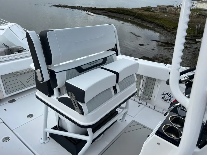 Slide: The Image of 2024 Blackfin 252 CC boat interior with white seating and coastal view. - 22