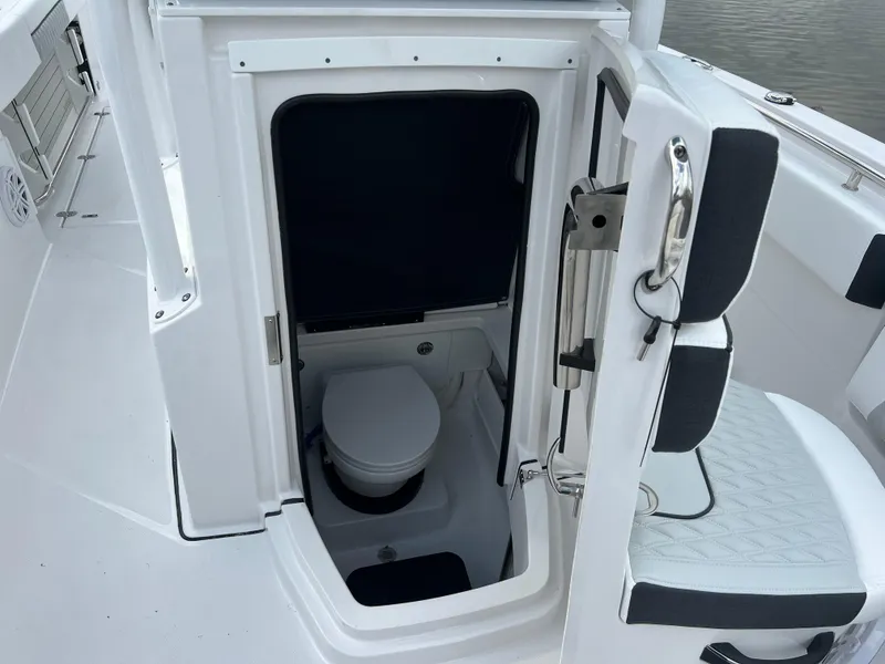 Slide: The Image of 2024 Blackfin 252 CC boat with open cabin door revealing a compact marine toilet. - 5
