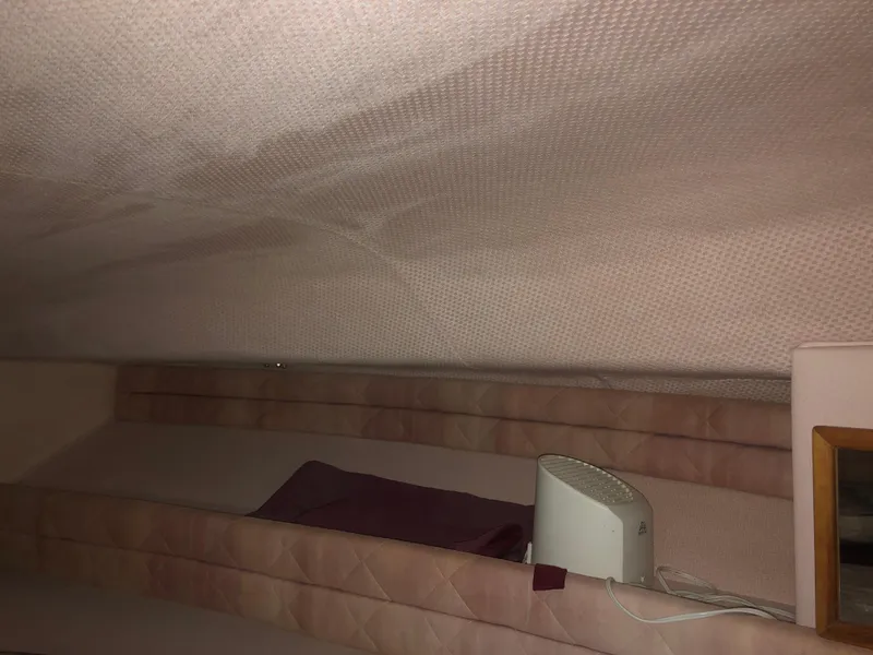 Slide: The Image of Interior cabin of 1989 Sea Ray 280 Sundancer with beige upholstery and small fan. - 10