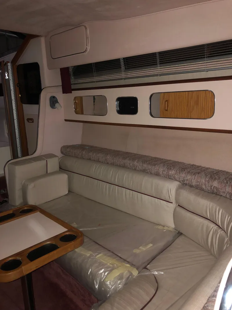 Slide: The Image of Interior of 1989 Sea Ray 280 Sundancer with beige seating and wooden accents. - 12