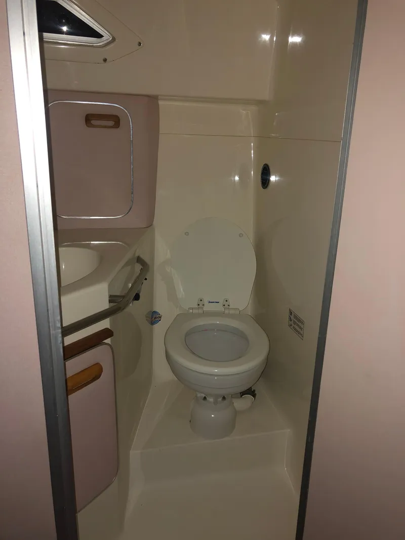 Slide: The Image of 1989 Sea Ray 280 Sundancer boat bathroom with toilet and sink. - 16