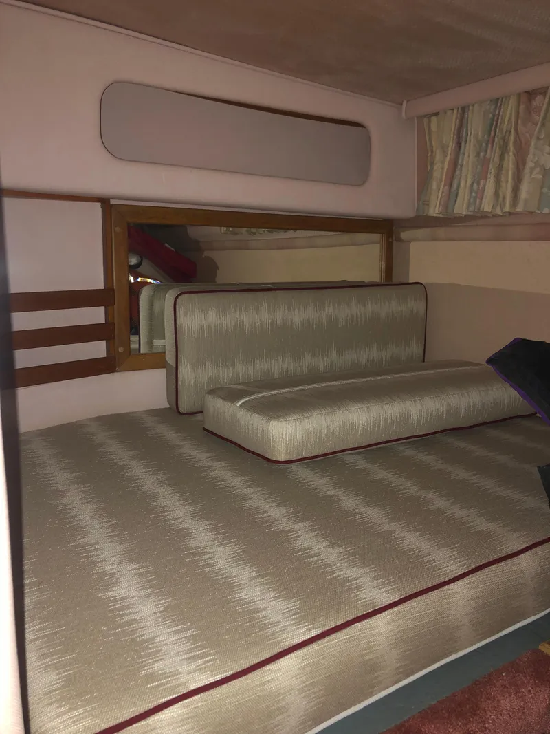 Slide: The Image of Interior cabin of 1989 Sea Ray 280 Sundancer with cushioned seating and wood accents. - 18