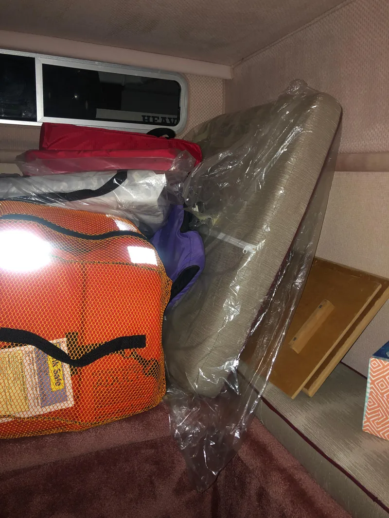 Slide: The Image of Interior of 1989 Sea Ray 280 Sundancer with cushions and bags. - 19