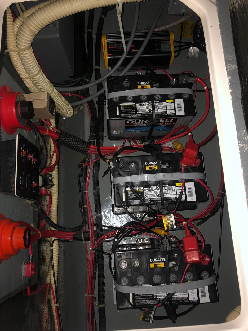Slide: The Image of Battery compartment of 1989 Sea Ray 280 Sundancer with multiple batteries and wiring. - 24